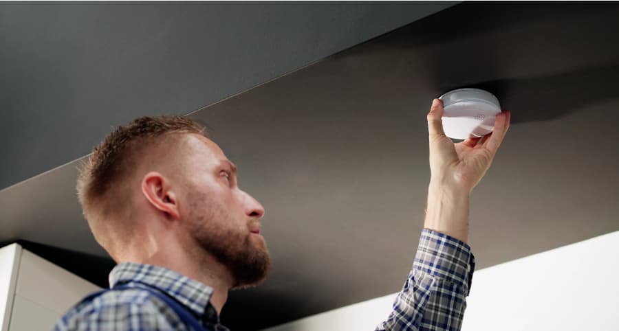 Man installing smoke detector inside a home